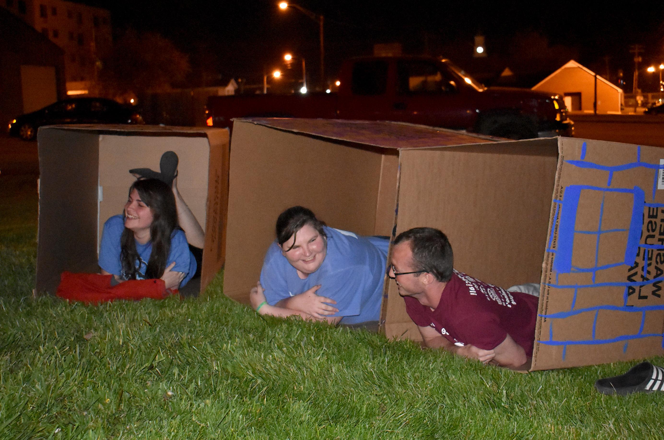 From left, Campbellsville University students Austin Tucker, Kendra Polston and Christy Ingram settle in their cardboard boxes for Cardboard Nation. (CU Photo by Alexandria Swanger)