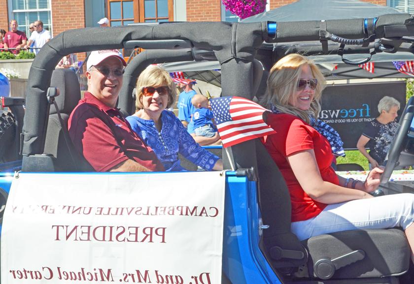 Campbellsville University President Michael V. Carter and his wife, Debbie, ride in the Campbellsville July 4 parade in downtown Campbellsville. Kristin Davis, office secretary for the president, drives them in her jeep. (Campbellsville University Photo by Joan C. McKinney)